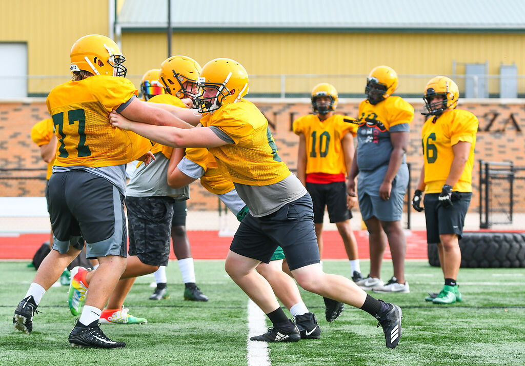 Members of the Rock Bridge defense run blocking drills